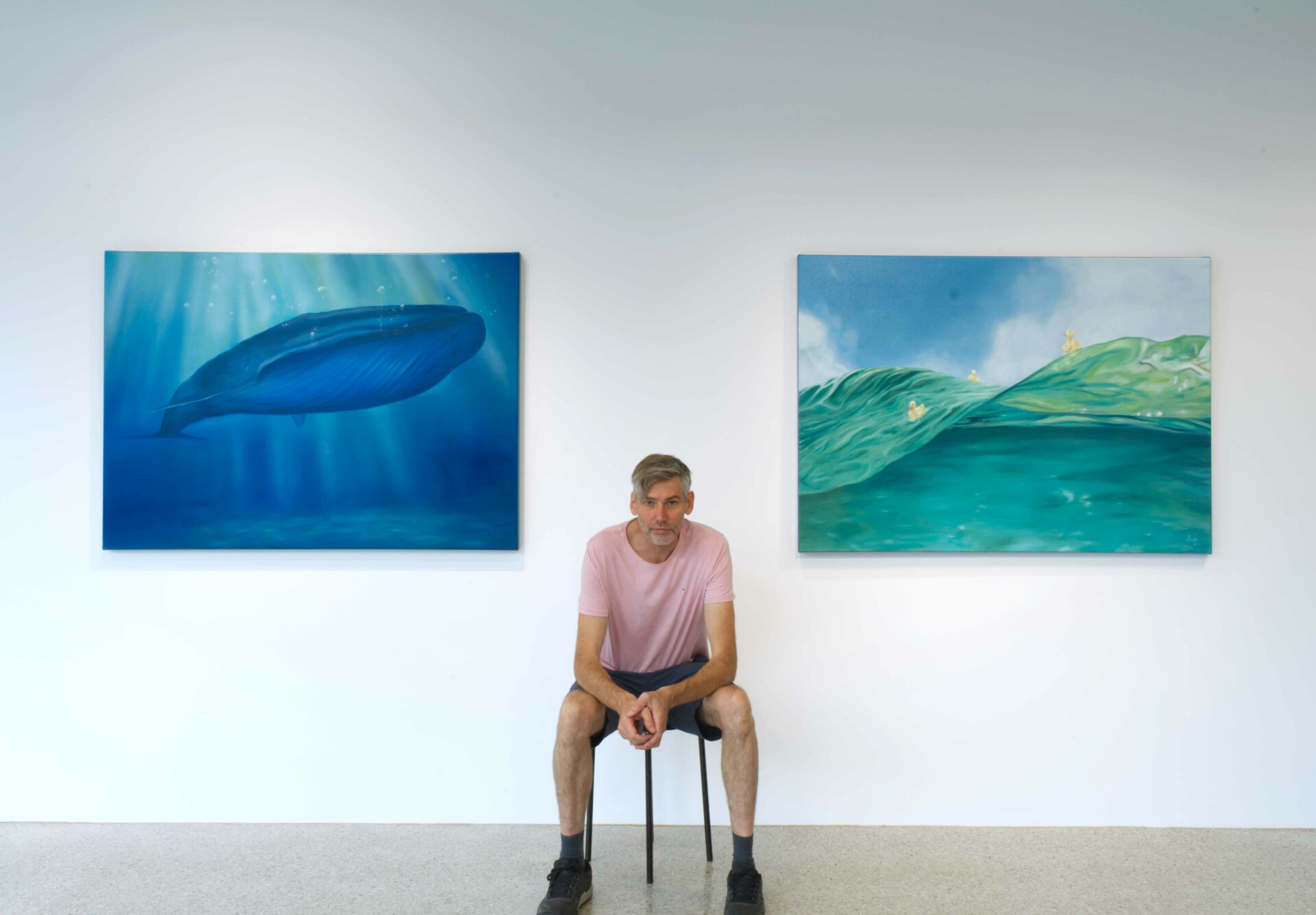 Martin Hörtnagl in einer Galerie vor zwei seiner Gemälde